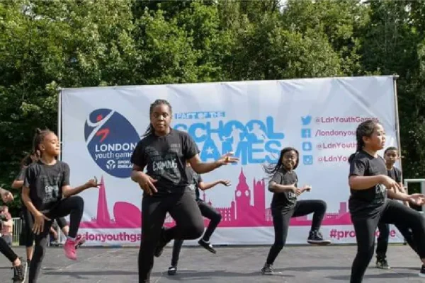 dancers wearing branded t-shirt with branded banner behind